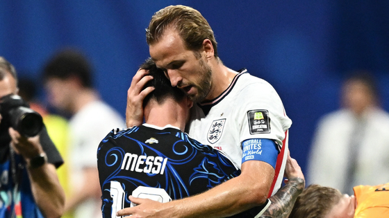Two soccer players hug.