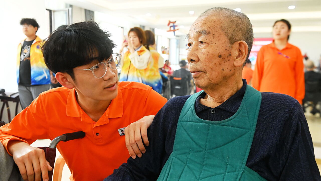 Elderly people are watching a performance at a nursing home.