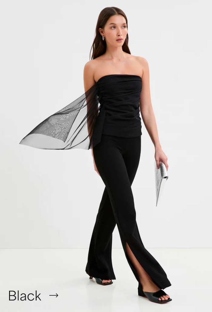 Yada in The Drea Top with sheer drape walks confidently beside a GIF of Carrie Bradshaw dancing in a white tank top and tutu.