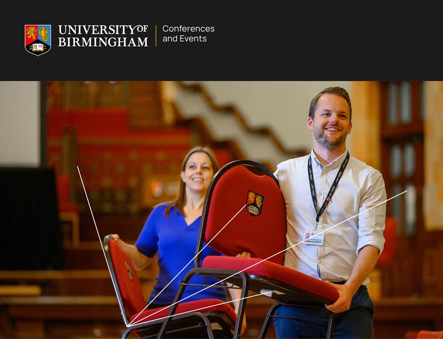 Two members of staff carrying chairs