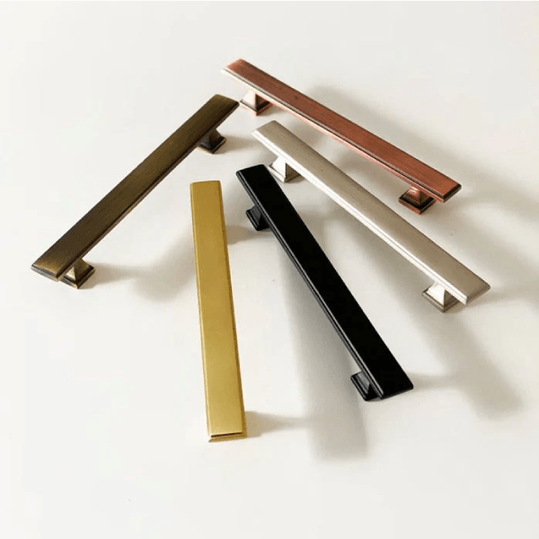 Five metallic drawer handles in various colors.