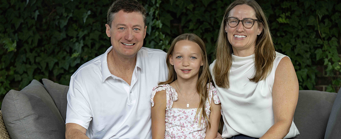 A man and woman sit next to a child.