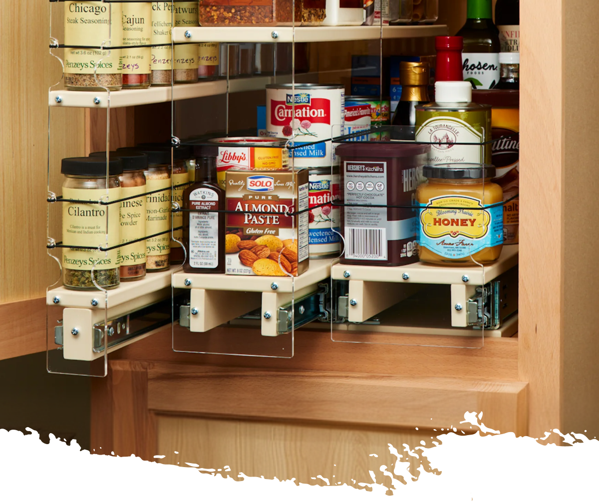 Tiered spice drawer organizer displaying neatly arranged spice jars and kitchen items in a pull-out cabinet system