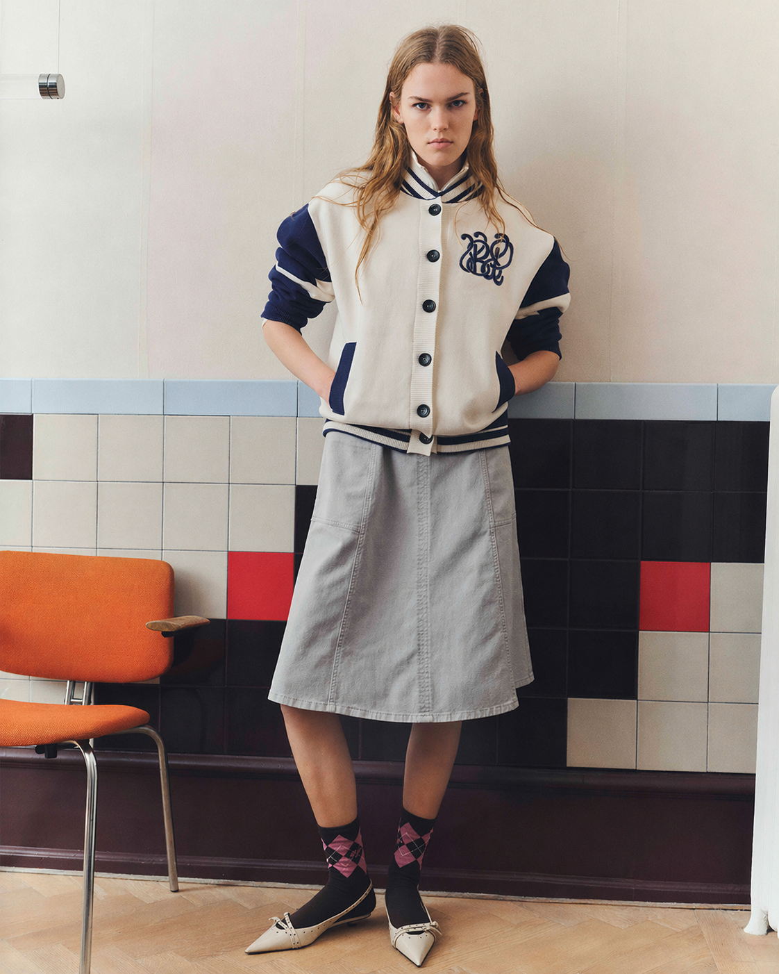 Girl in bomber jacket and grey skirt