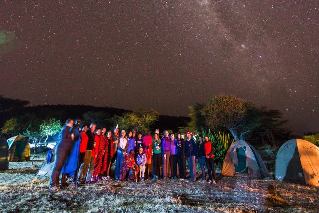 Campers posing beneath the stars