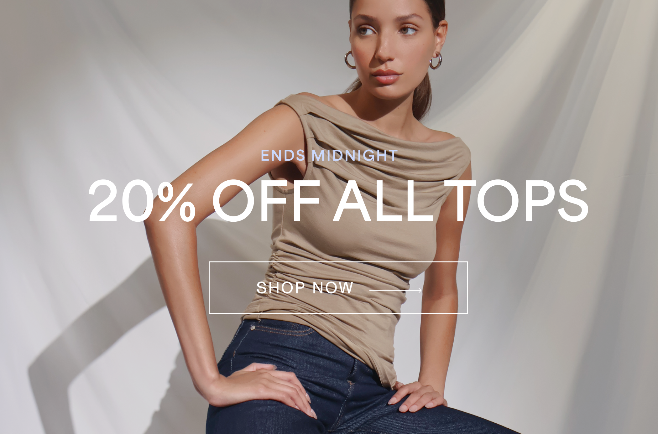 Carmel in The Cooper Sleeveless Top and jeans with text overlay “ENDS MIDNIGHT 20% OFF ALL TOPS SHOP NOW →”A