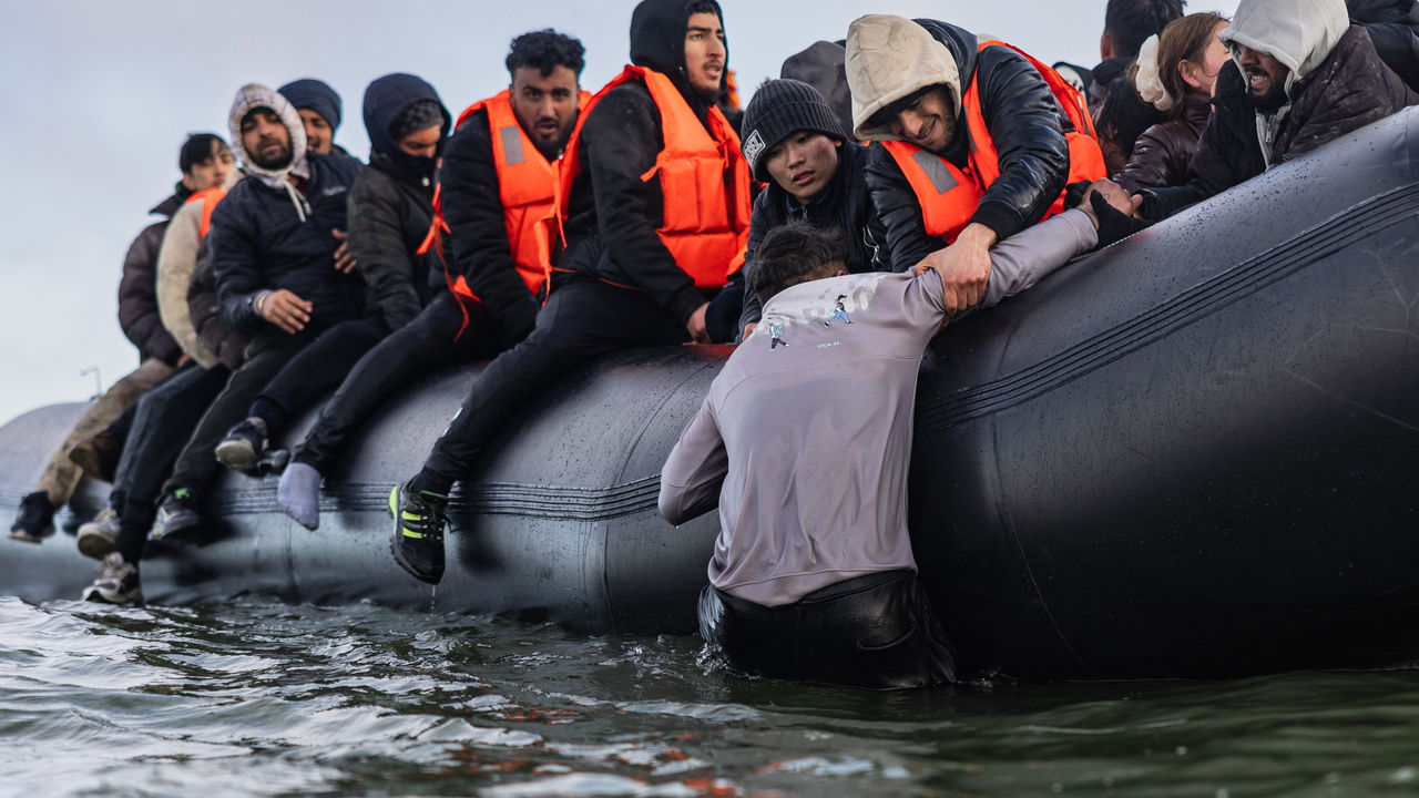 Migrants board a smuggler's boat in an attempt to cross the English Channel