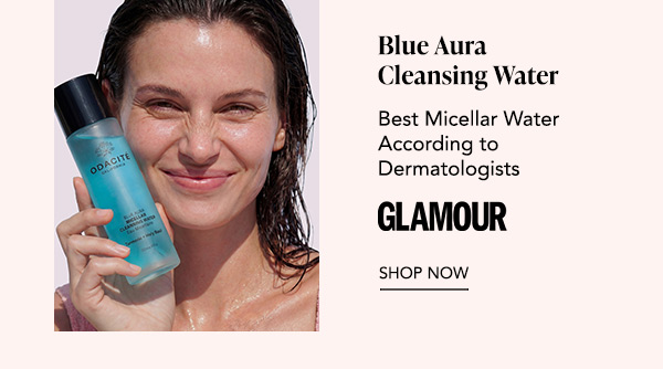 Smiling model holding Odacité Blue Aura Cleansing Water bottle, featuring Glamour quote “Best Micellar Water According to Dermatologists” and Shop Now.