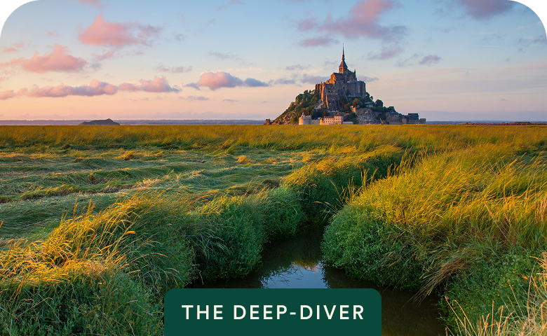 Mont Saint-Michel at golden hour with The Deep-Diver badge on Grand Tour of France — opens itinerary.