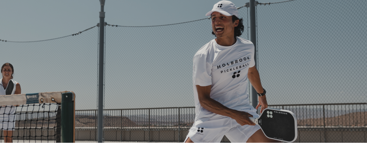 Person Playing pickleball with a light blue sky background