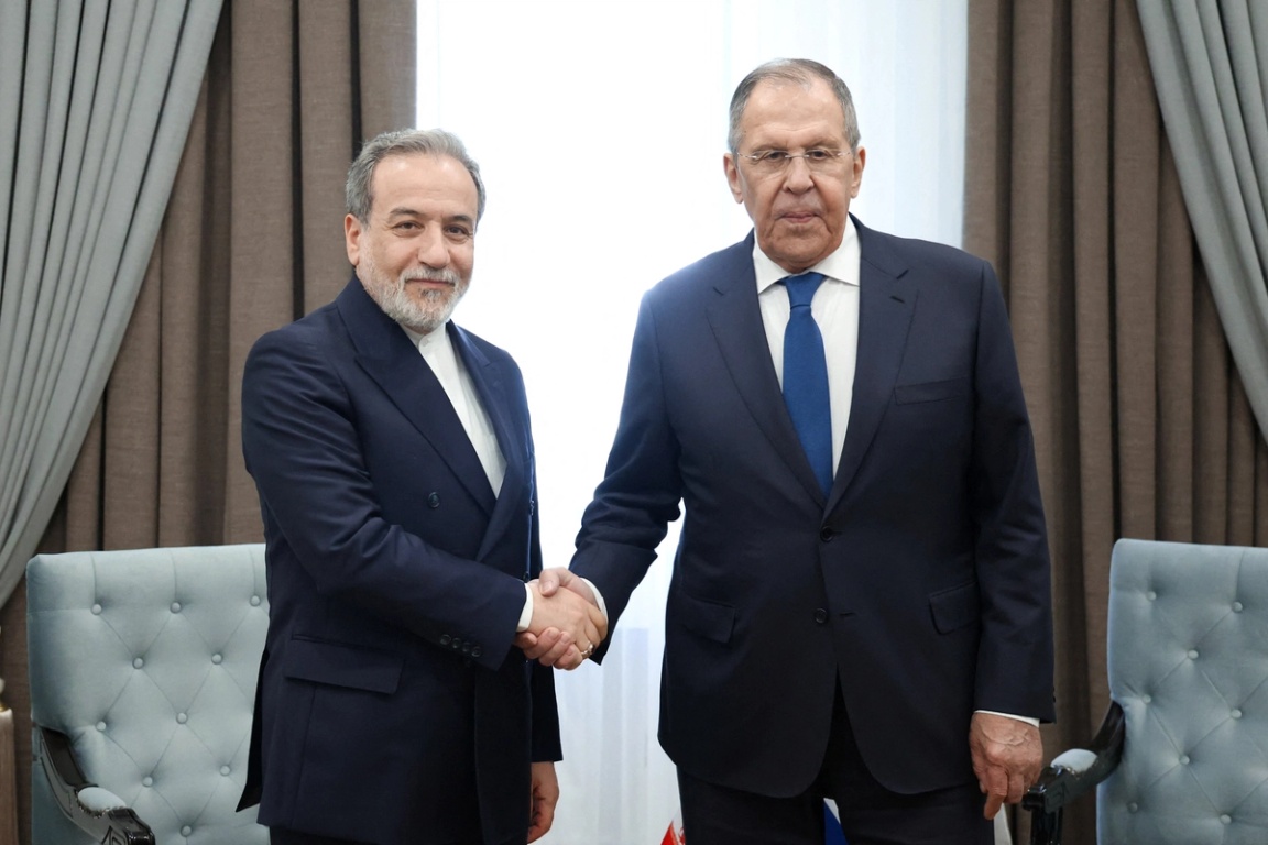 Russian Foreign Minister Sergei Lavrov shakes hands with Iranian Foreign Minister Abbas Araqchi during their talks on the sidelines of the Shanghai Cooperation Organisation