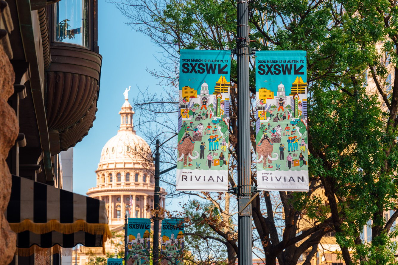 Two small SXSW banners hang from a lamppost with the Texas capitol building in the background