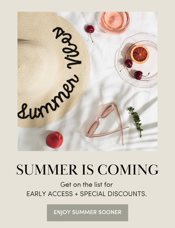 flatlay of a hat that says "summer vibes" and a glass of wine, fruit, and sunglasses