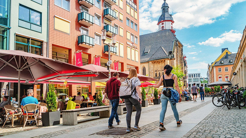 Image description: Friends walking past a restaurant in Chemnitz, Germany.
