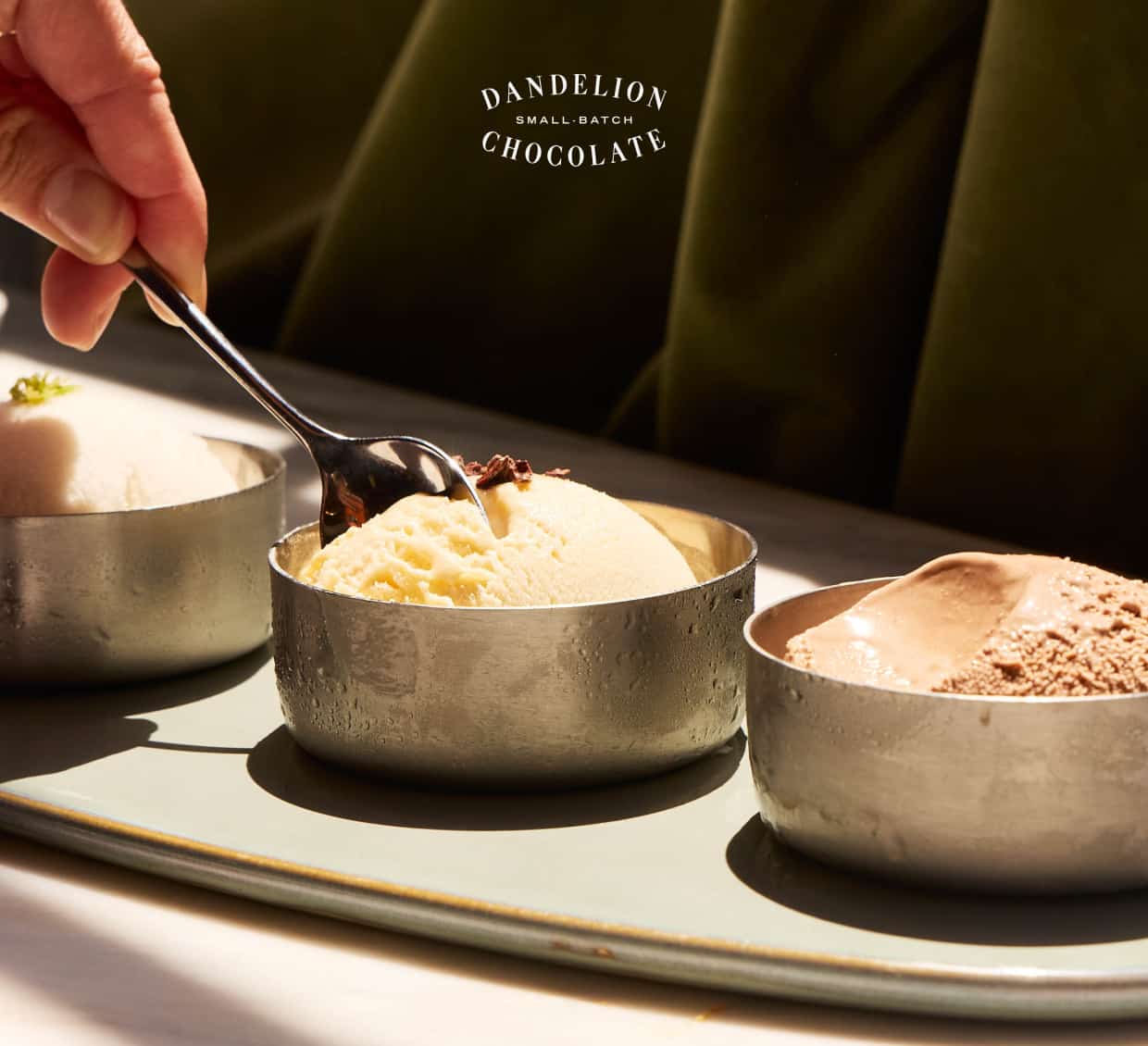 Three scoops of ice cream, each in a petite silver dish. 