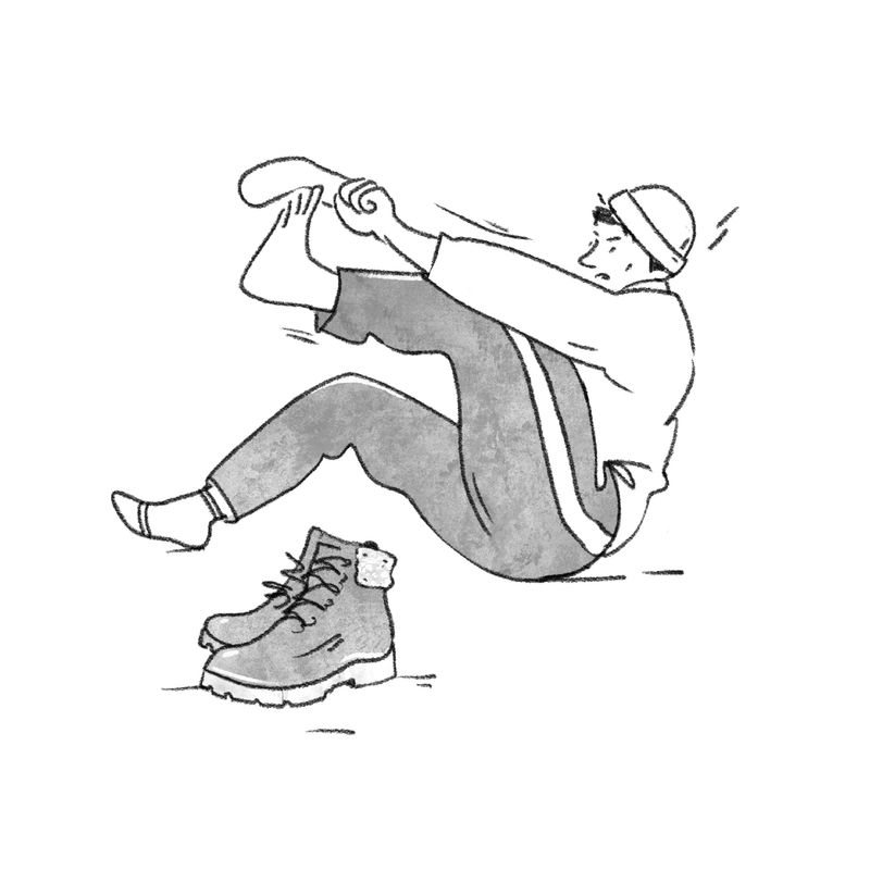 Man trying to put on three layers of socks.