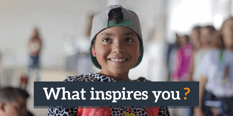 A photo of a person smiling, looking up at the camera, with text that reads “What inspires you?”