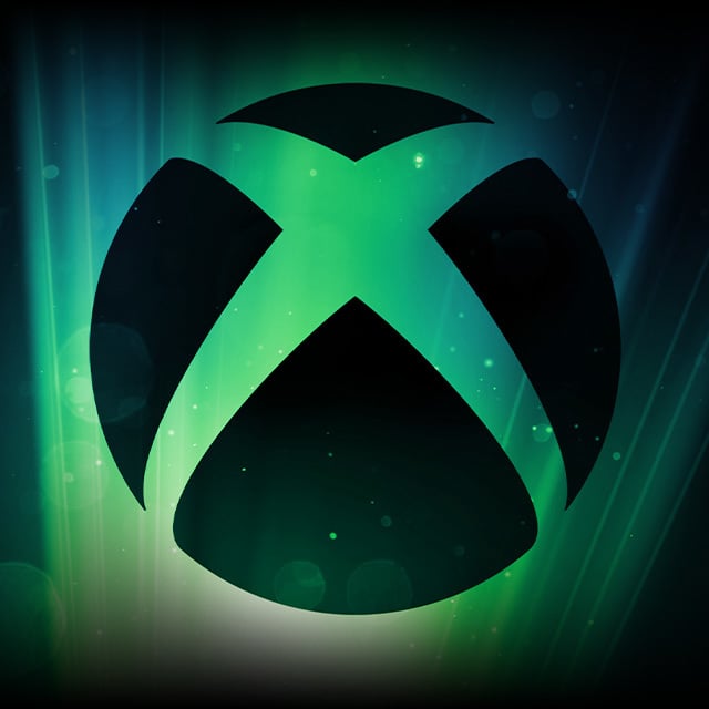 An Xbox shield logo illuminated from behind with rising beams of light.
