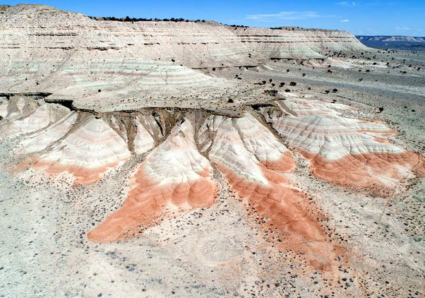 Dark red and green mudstone beds with tan sand-dominated layers pictured from above