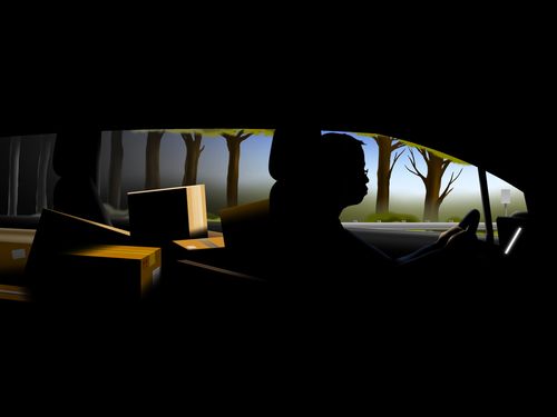 Man driving a car filled with boxes.