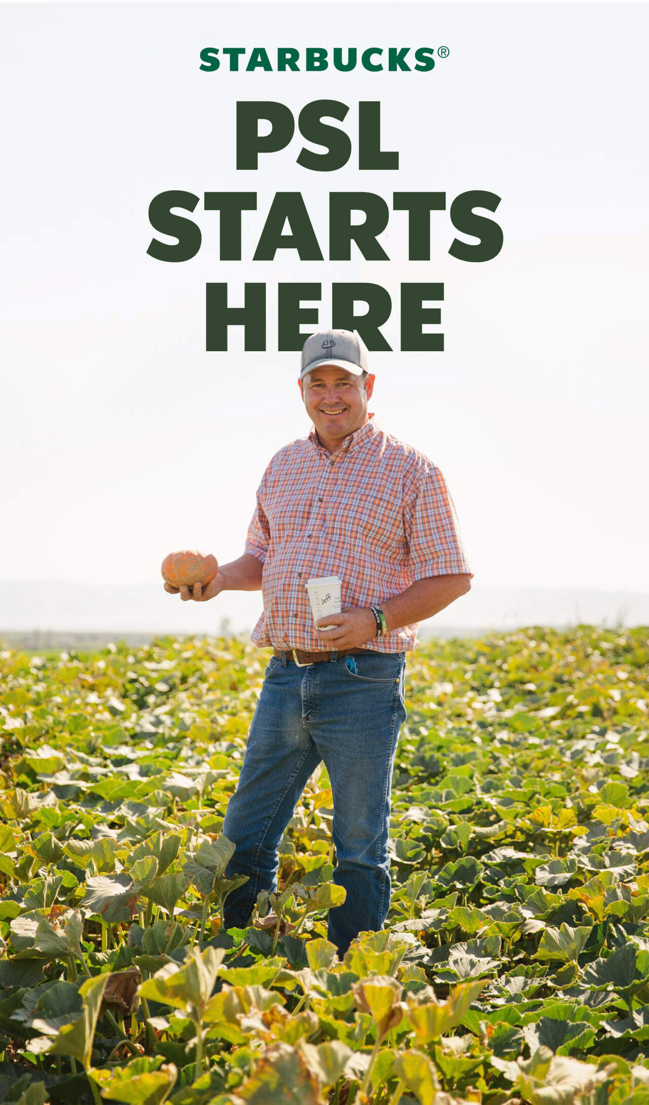 STARBUCKS® | Farmer Jeff Leber stands on a pumpkin farm, holding a kabocha pumpkin in one hand and a white to-go cup with his name on it in the other. It reads "PSL starts here."