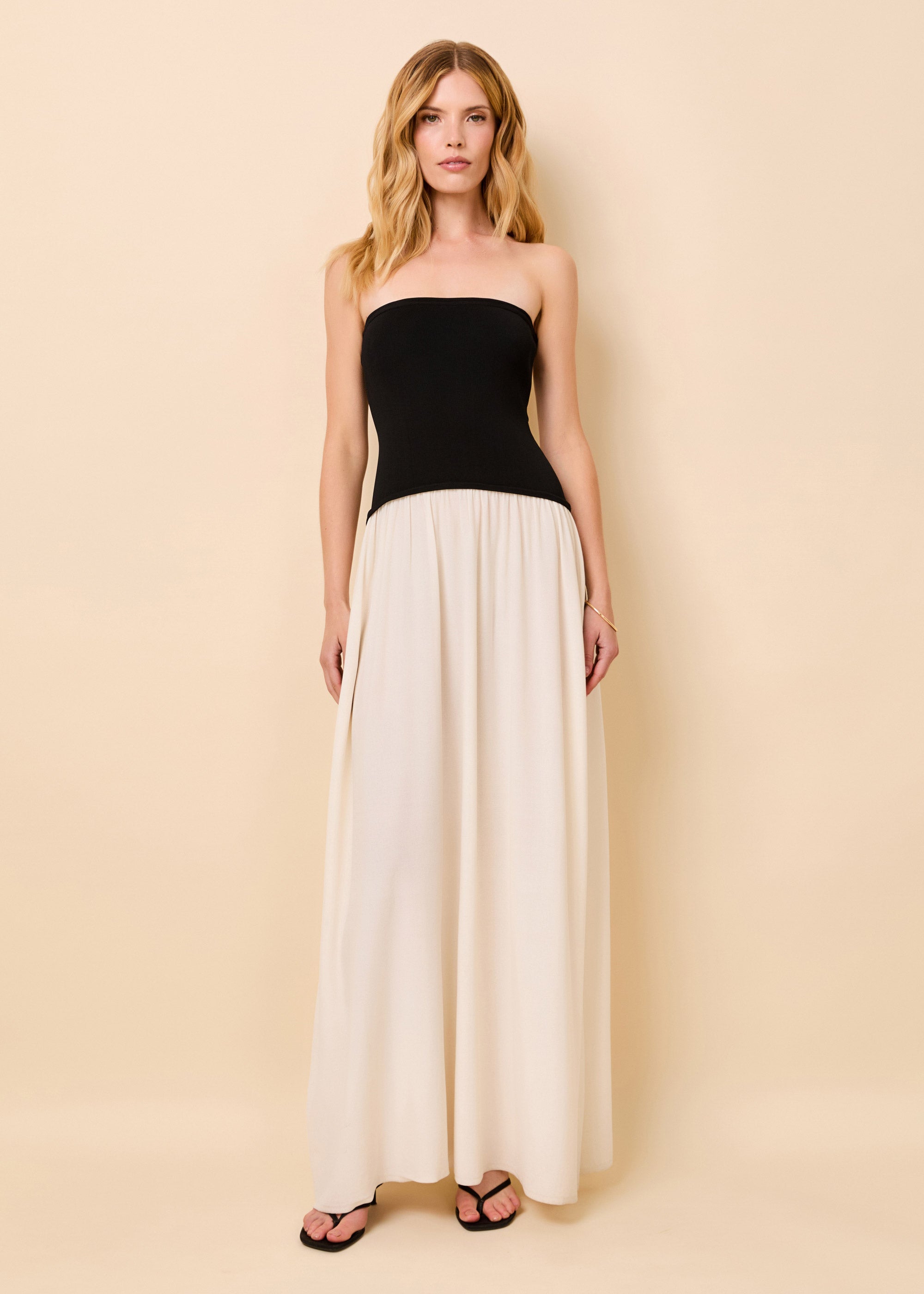 Woman in a strapless full length dress with a black top and white dress bottom