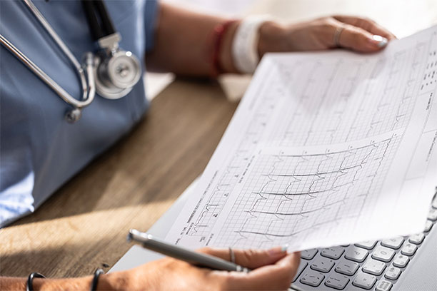 A doctor examines a chart of heart activity.