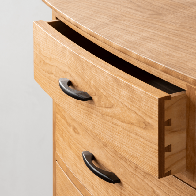 A detail image of the crescent dresser with the drawer open.