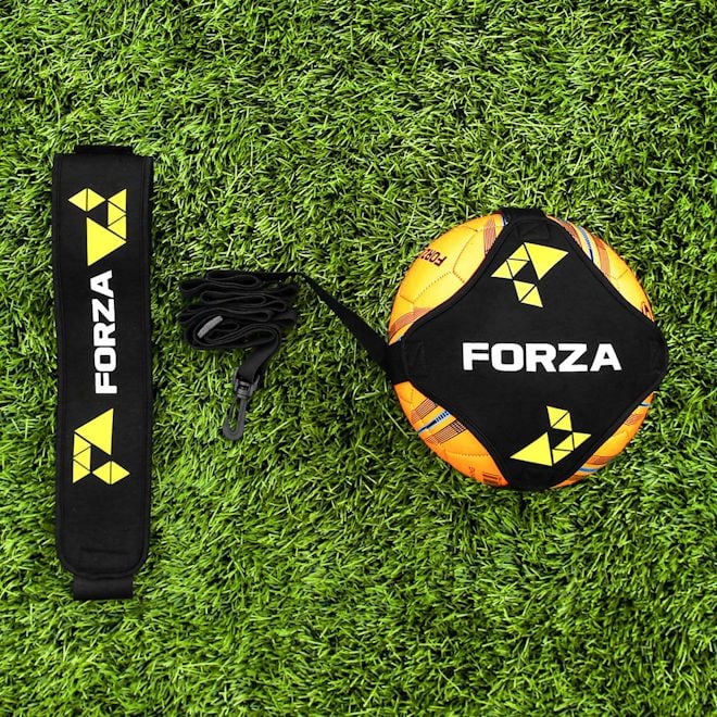 FORZA Solo Soccer Kick Trainer with orange training ball on an artificial pitch.