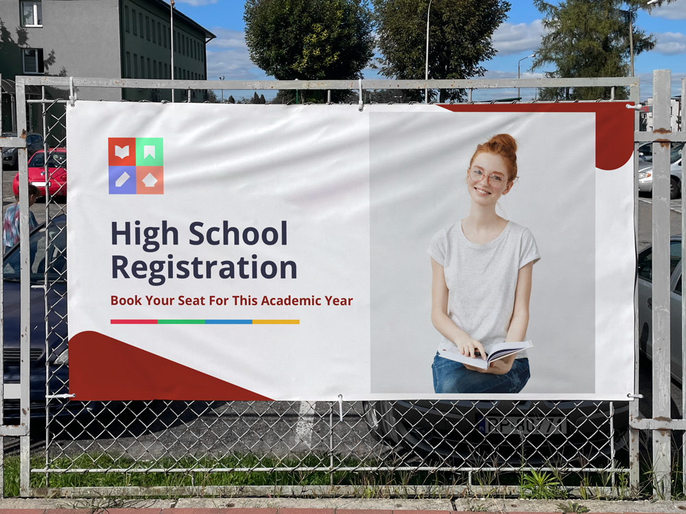 Outdoor vinyl banner advertising high school registration with a student holding a notebook and enrollment information.