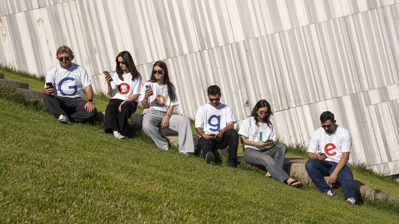  People, dressed in white t-shirts with the letters of 'Google', pose for a photo.