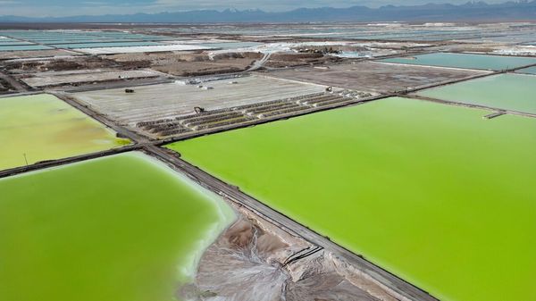 An aerial view of brine evaporating in pools at the lithium extraction plant facilities of the SQM Lithium company near Peine, Chile.
