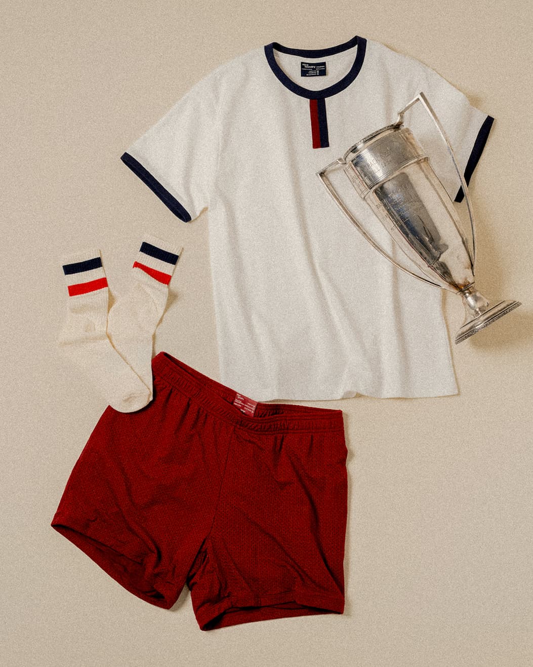 A pair of white boxer briefs with red/white/blue waistband sitting on red lounge shorts inside of a car.