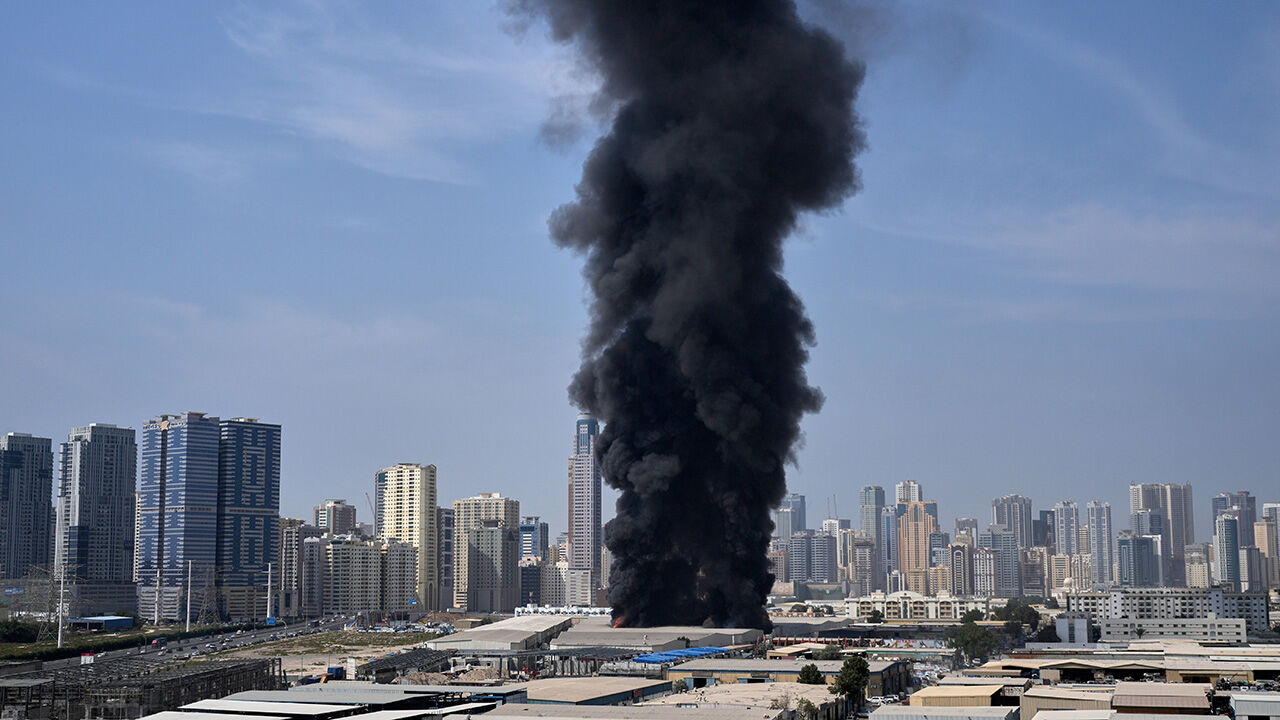 A black plume of smoke rises from a warehouse at the industrial area of Sharjah City in the United Arab Emirates following reports of Iranian strikes in Dubai, United Arab Emirates, Sunday, March 1, 2026