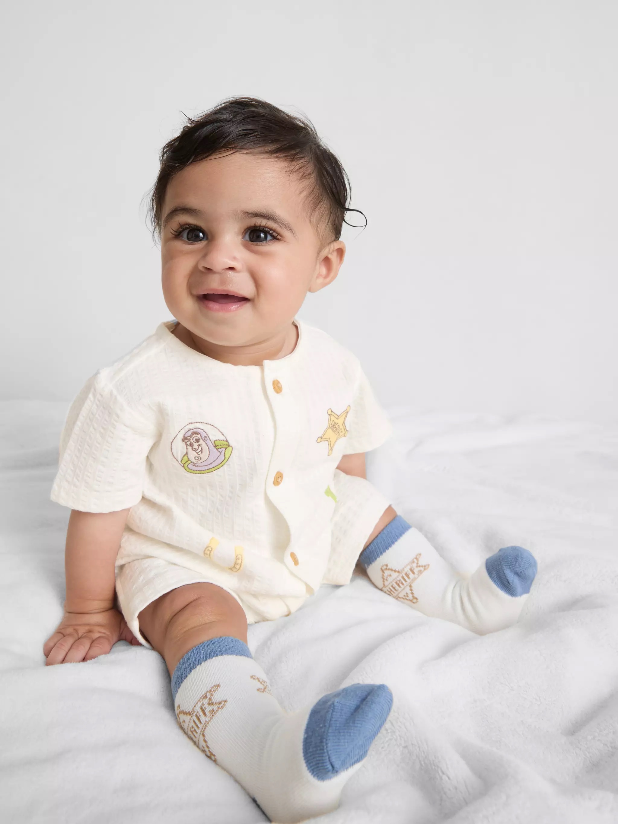 Baby wearing a Disney Pixar’s Toy Story Newborn Romper