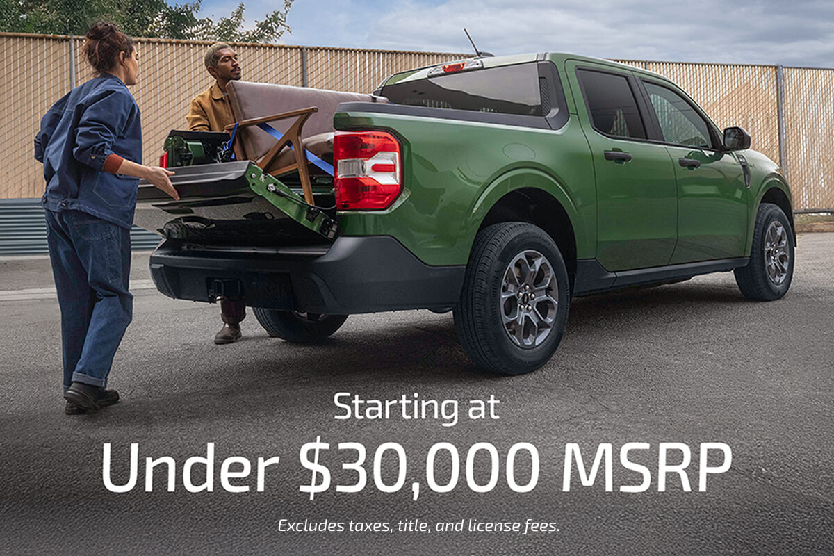 Two people loading furniture into the bed of a Maverick&reg; truck, with the words &ldquo;Starting at Under $30,000 MSRP&rdquo; and &ldquo;Excludes taxes, title, and license fees.&rdquo; on the image 