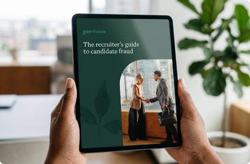 Image-of-someone-holding-the-recruiters-guide-to-candidate-fraud-on-a-tablet-in-office