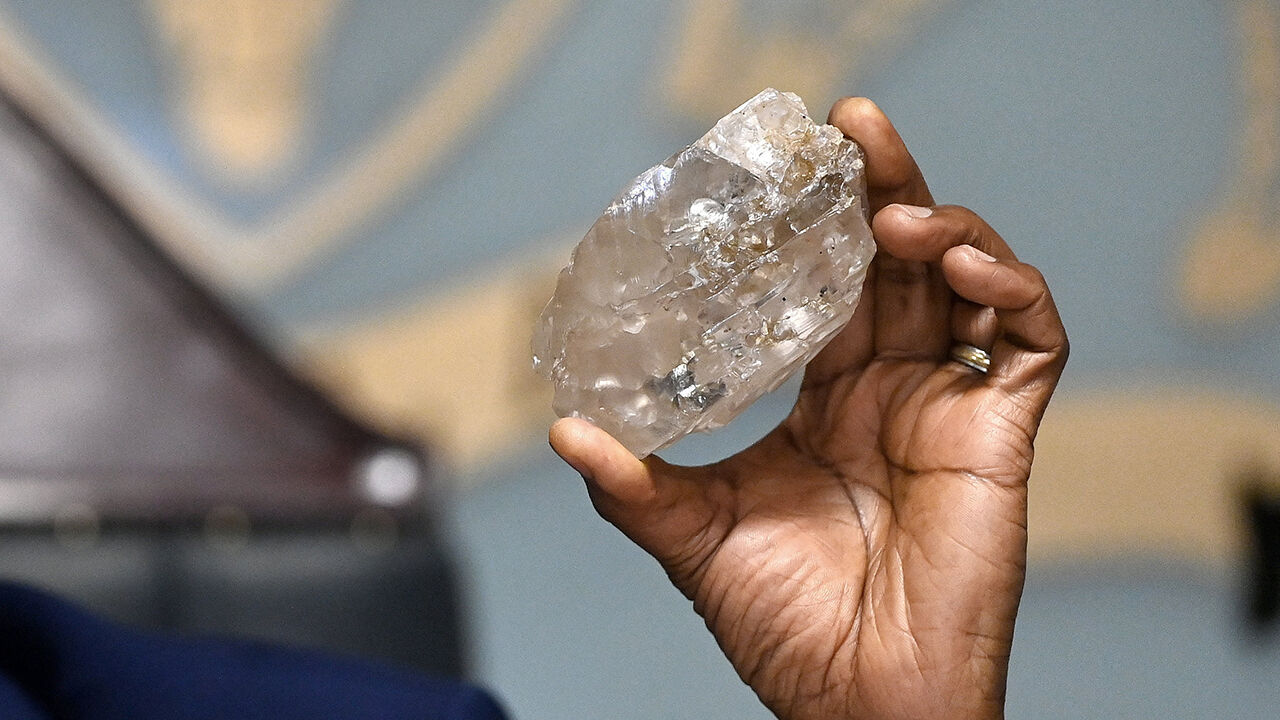 Botswana's president, Mokgweetsi Masisi, holds a large diamond discovered in Botswana at his office in Gaborone