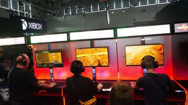Fairgoers play games at the Xbox booth at the Cologne trade fair center.
