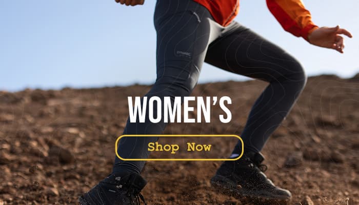 Action shot of a woman wearing Craghoppers Dynamic Leggings while scree-surfing down a mountain slope.