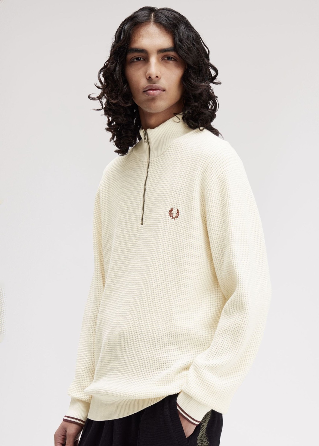 A male model wearing a Fred Perry Waffle Stitch Half-Zip Jumper in Ecru