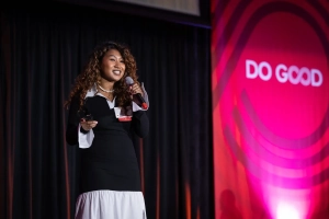 student presents on stage, with Do Good logo at right