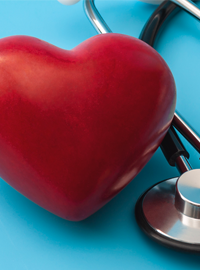 Red heart and stethoscope isolated on blue background.