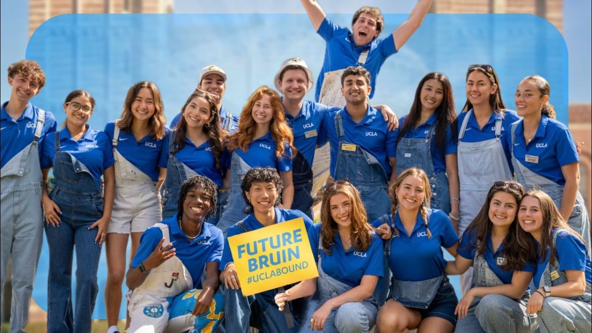 A big group of students wearing blue UCLA polo shirts smiling; one holds a yellow sign with "Future Bruin #UCLABOUND" on it.