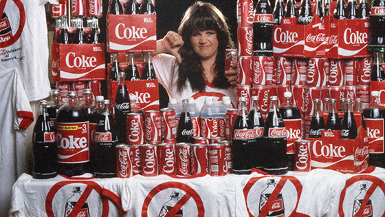 A woman surrounded by bottles of Coke.