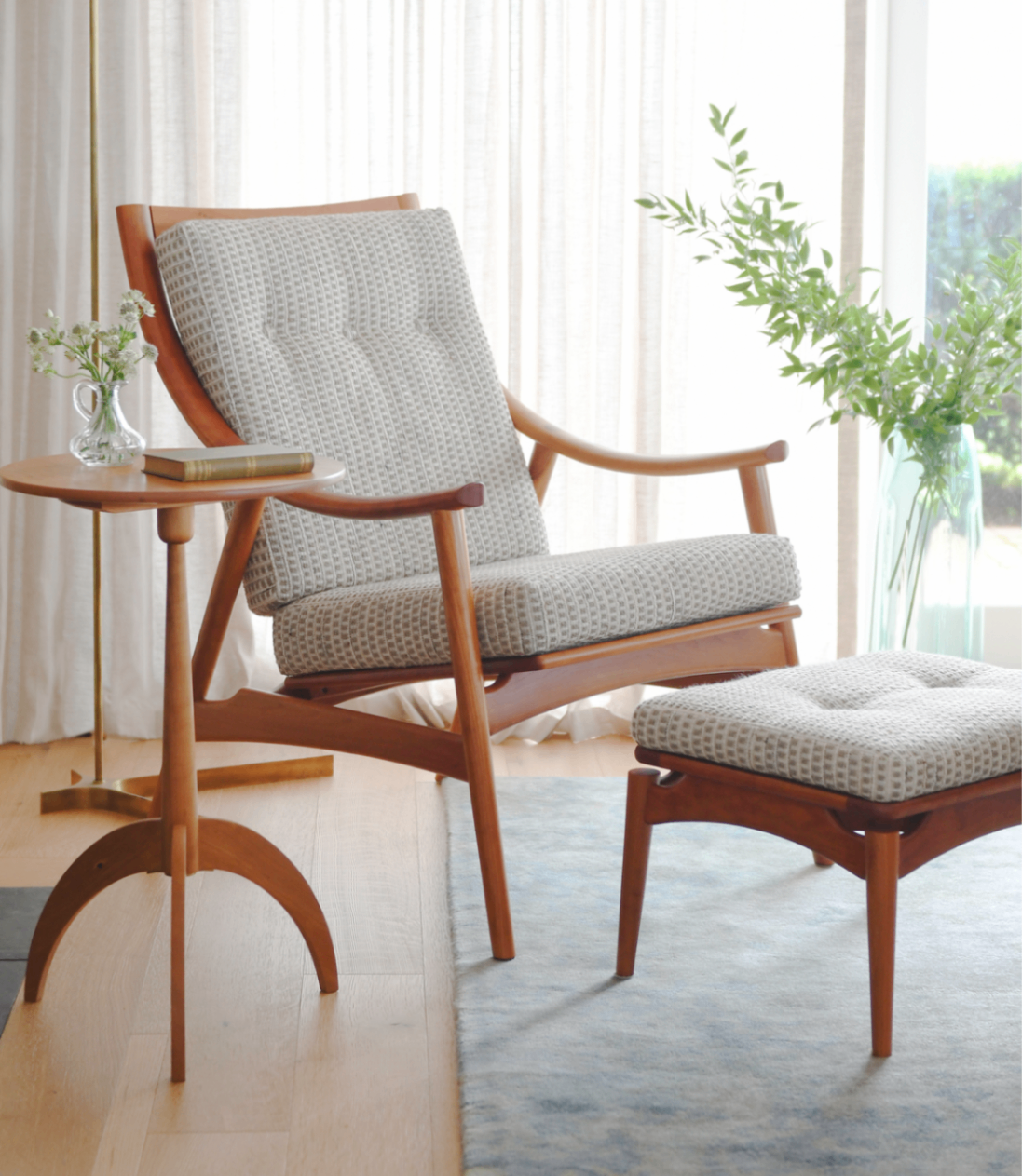 The Ellipse Lounge Chair and ottoman with the Shaker Round Stand