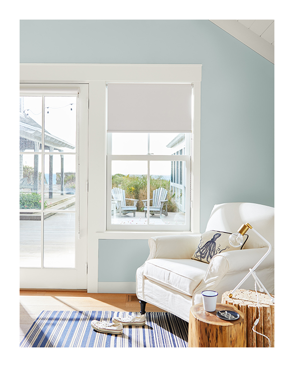A light-blue painted wall with white trim and a white armchair.
