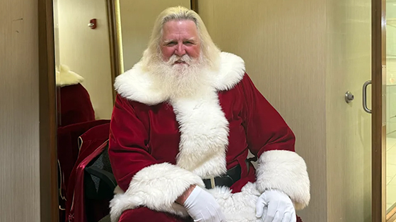 A man dressed as Santa Clause sits for a portrait.