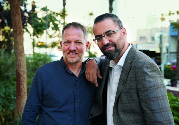 Maoz Inon (left) and Aziz Abu Sarah pose together smiling for a portrait