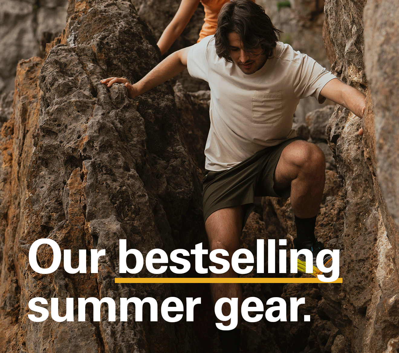 'Our bestselling summer gear' text over the image of 2 people scrambling wearing Rab gear.